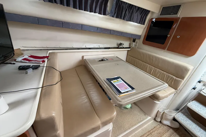 Slide: The Image of Interior of 2004 Wellcraft 330 Coastal boat with beige seating and table setup. - 19