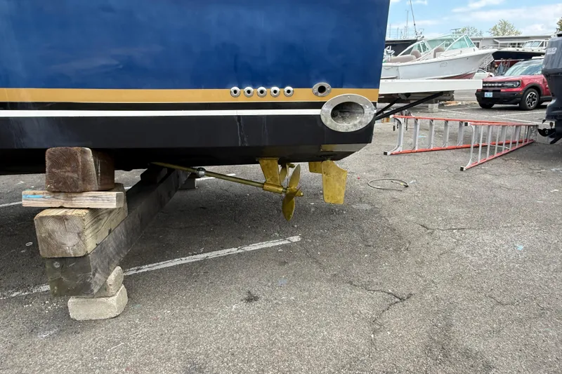 Slide: The Image of 2004 Wellcraft 330 Coastal boat on blocks, showing propeller and hull details. - 3