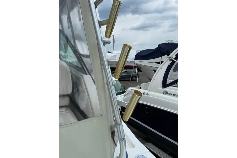 Slide: The Image of 2004 Wellcraft 330 Coastal boat with rod holders, docked beside another vessel. - 4