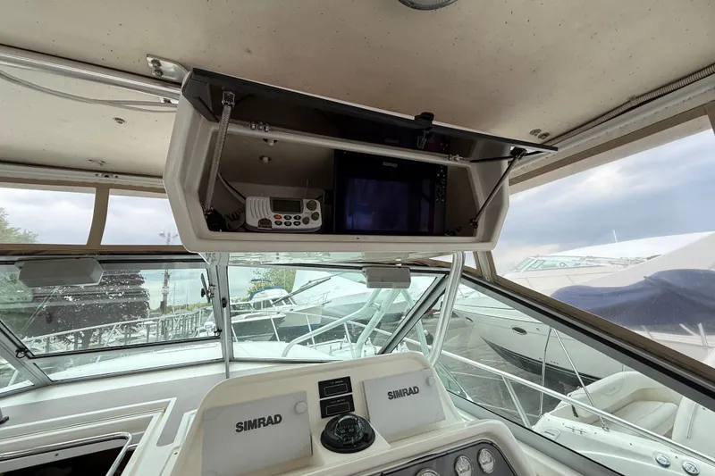 Slide: The Image of 2004 Wellcraft 330 Coastal helm with Simrad electronics and overhead storage. - 6
