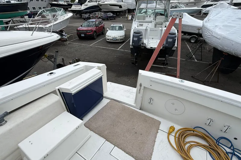 Slide: The Image of 2004 Wellcraft 330 Coastal boat in a marina, surrounded by other boats and vehicles. - 7