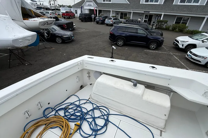 Slide: The Image of 2004 Wellcraft 330 Coastal boat deck with coiled ropes, parked cars, and nearby buildings. - 8