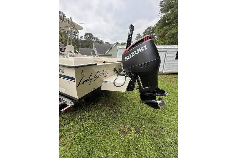 Slide: The Image of 1981 Grady-White boat with Suzuki outboard motor, parked on grass. - 3