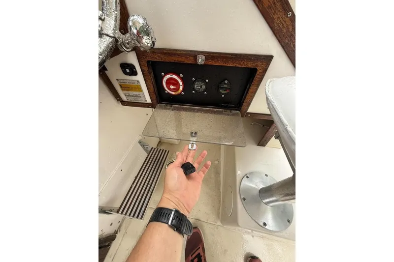 Slide: The Image of Hand operating controls on a 1981 Grady-White boat dashboard. - 7