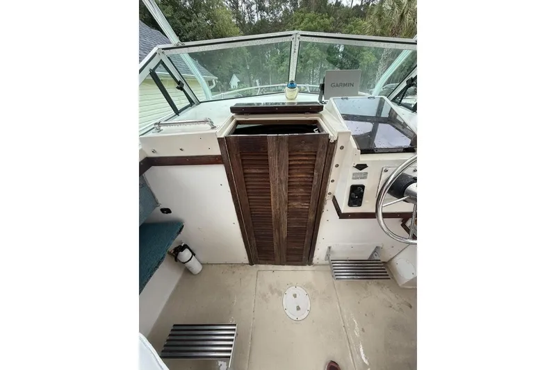Slide: The Image of 1981 Grady-White boat cockpit with wooden door, steering wheel, and Garmin device. - 10