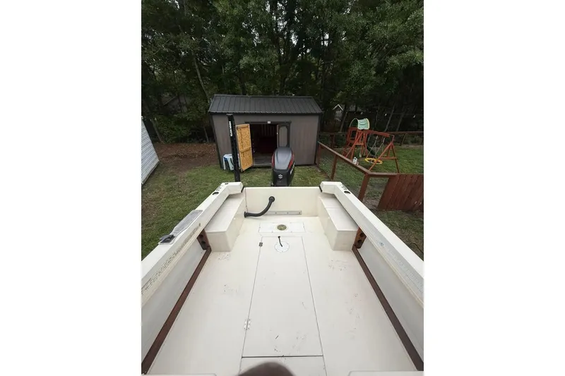 Slide: The Image of 1981 Grady-White boat interior with outboard motor, backyard shed, and swing set. - 2