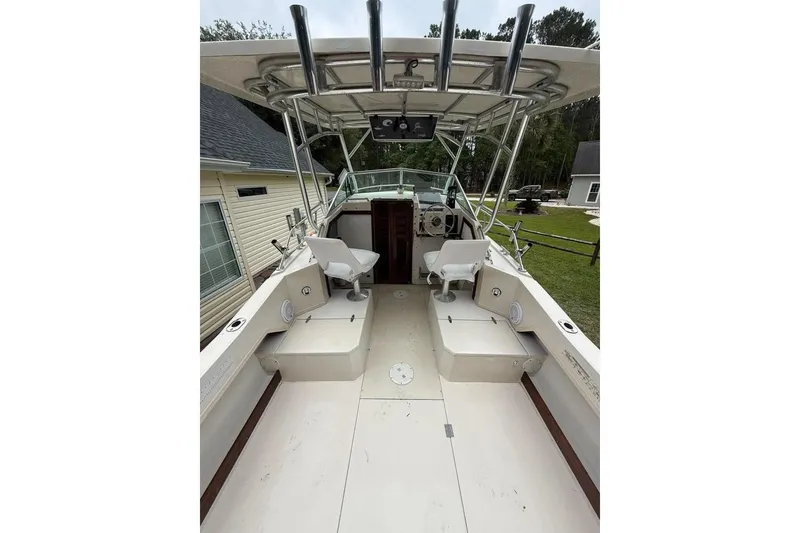 Slide: The Image of 1981 Grady-White boat interior with dual seats and steering console, parked outdoors. - 5