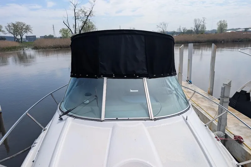 Slide: The Image of 2002 Maxum 2700 SCR boat docked by a calm river with a black canopy. - 10