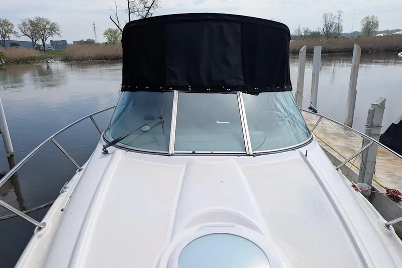 Slide: The Image of 2002 Maxum 2700 SCR boat docked, featuring a black canopy and sleek windshield design. - 11