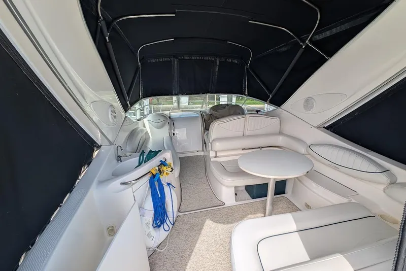 Slide: The Image of Interior of 2002 Maxum 2700 SCR boat with seating and table under canopy. - 12