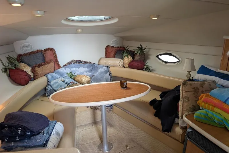Slide: The Image of Cozy interior of 2002 Maxum 2700 SCR boat with cushions and table. - 26