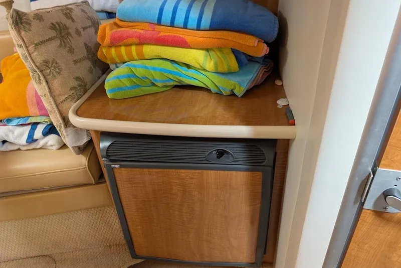 Slide: The Image of Colorful towels stacked on a wooden counter inside a 2002 Maxum 2700 SCR boat. - 28