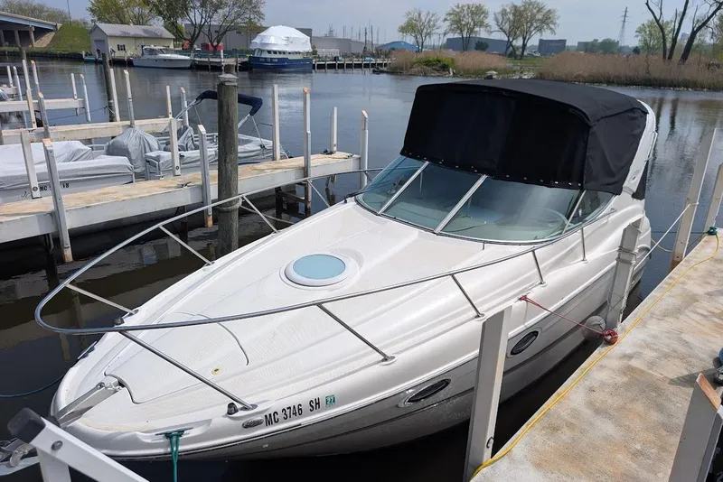 Slide: The Image of 2002 Maxum 2700 SCR boat docked at a marina, featuring a sleek design and black canopy. - 3