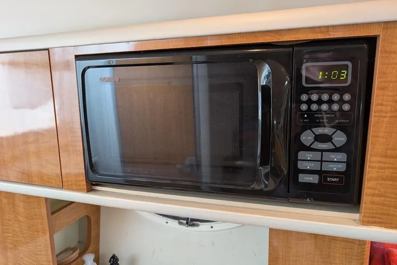 Slide: The Image of Built-in microwave in 2002 Maxum 2700 SCR boat kitchen, displaying time 1:03. - 30