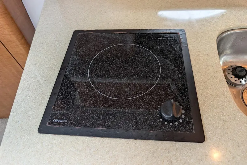 Slide: The Image of Ceramic cooktop on 2002 Maxum 2700 SCR boat, featuring a single burner and control knob. - 31