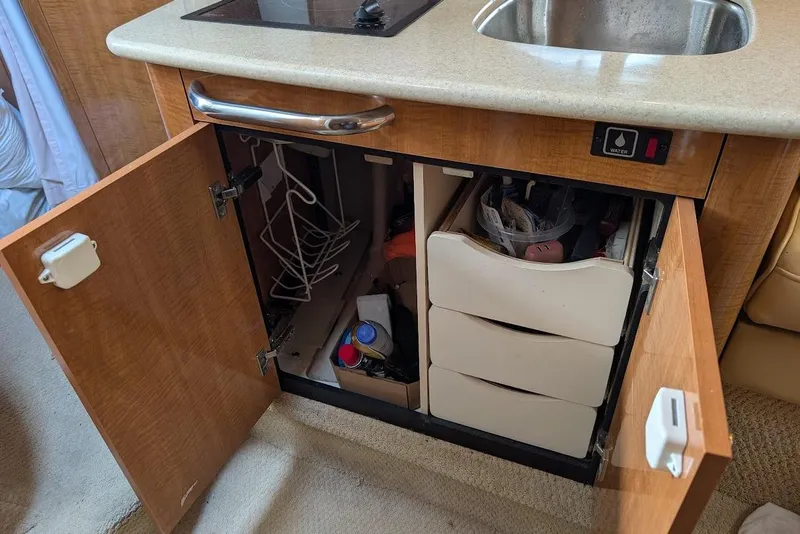 Slide: The Image of Open cabinet in 2002 Maxum 2700 SCR boat kitchen, showing storage and sink area. - 33