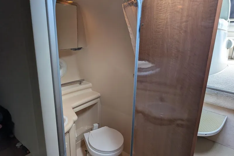 Slide: The Image of Compact bathroom in 2002 Maxum 2700 SCR boat, featuring toilet and mirror cabinet. - 35