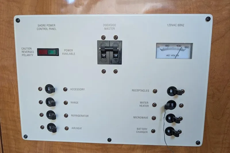 Slide: The Image of Shore power control panel on 2002 Maxum 2700 SCR boat, featuring switches and voltage meter. - 39