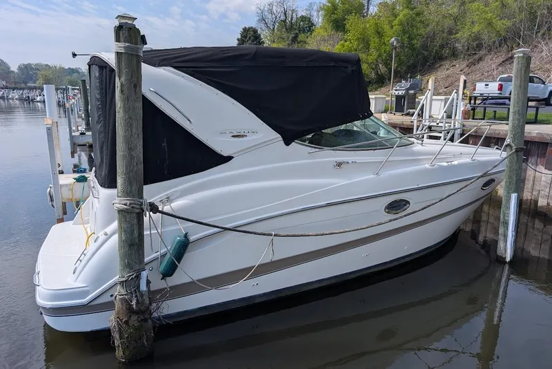 Slide: The Image of 2002 Maxum 2700 SCR boat docked at marina with black canopy. - 4