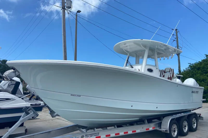 The Image of 2026 Regulator 28 boat on trailer under clear blue sky. - 0