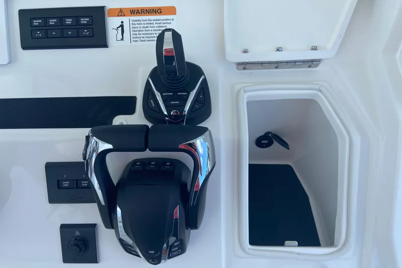 Slide: The Image of 2026 Regulator 28 boat controls with warning label and storage compartment. - 16