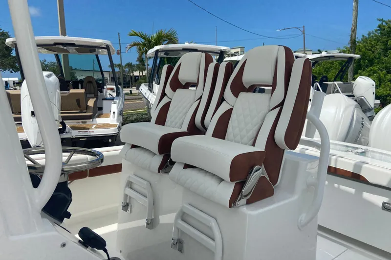 Slide: The Image of Luxury seating on a 2026 Regulator 28 boat, featuring plush white and brown upholstery. - 19