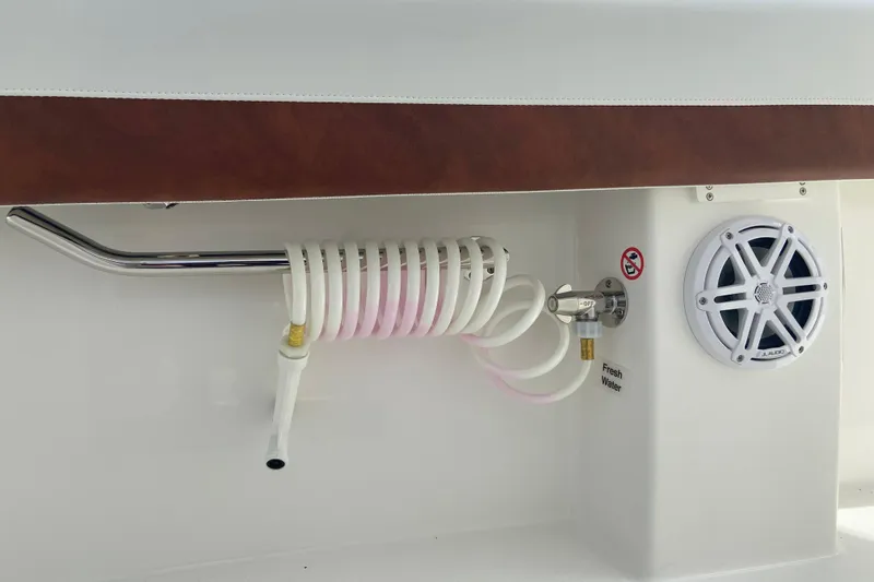 Slide: The Image of 2026 Regulator 28 boat detail with coiled hose, speaker, and fresh water outlet. - 22