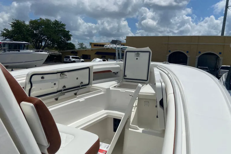 Slide: The Image of 2026 Regulator 28 boat interior with open storage compartments under a cloudy sky. - 26