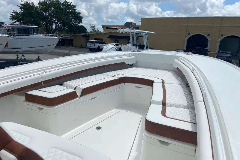 Slide: The Image of 2026 Regulator 28 boat with white and brown seating, docked outdoors. - 27