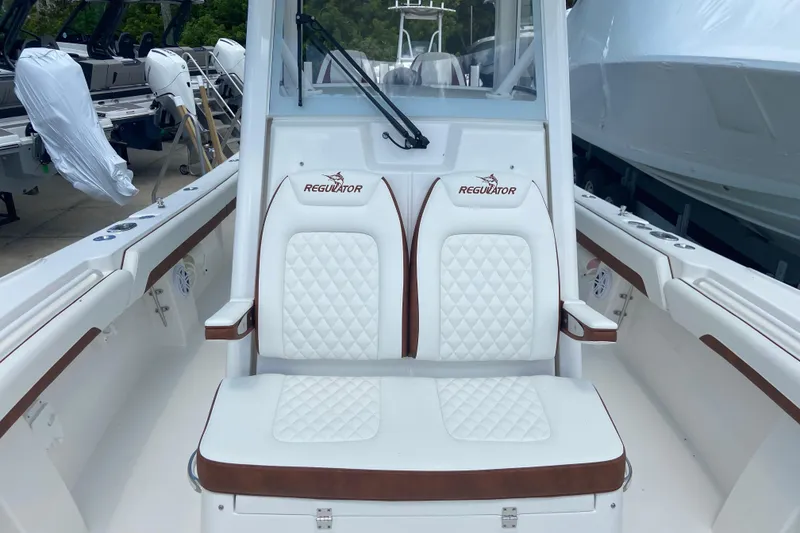 Slide: The Image of 2026 Regulator 28 boat interior with white quilted seats and brown accents. - 30