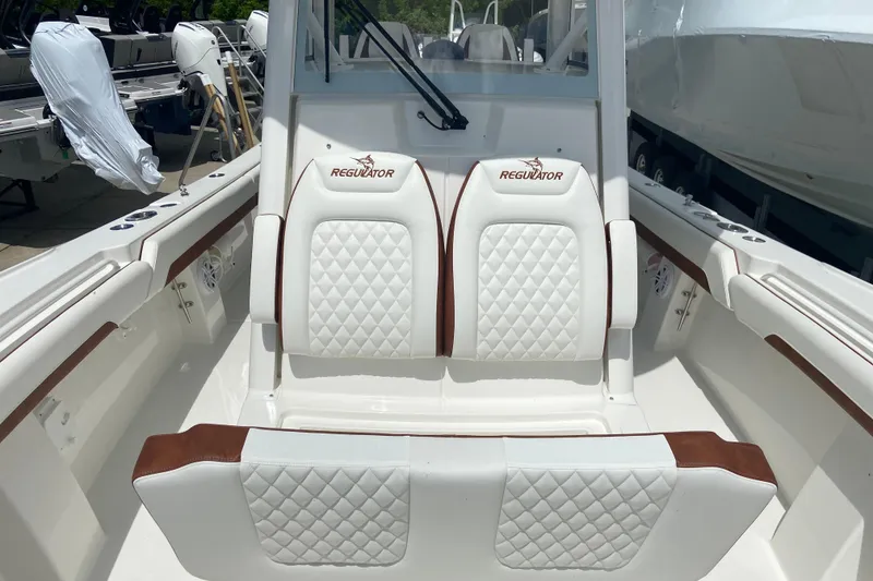 Slide: The Image of 2026 Regulator 28 boat interior with white quilted seats and brown accents. - 31