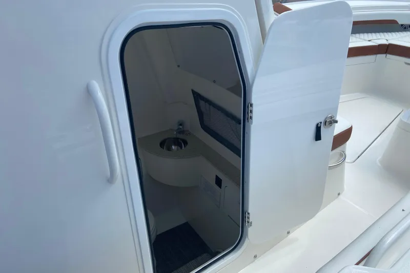 Slide: The Image of 2026 Regulator 28 boat interior with open door revealing compact sink area. - 33