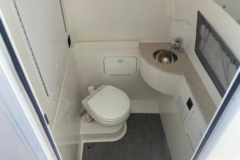 Slide: The Image of 2026 Regulator 28 boat interior bathroom with toilet, sink, and storage. - 34