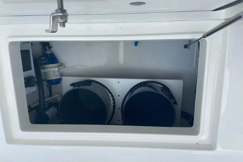 Slide: The Image of Storage compartment in a 2026 Regulator 28 boat, featuring equipment and buckets. - 5