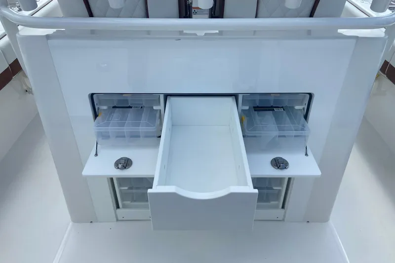 Slide: The Image of 2026 Regulator 28 boat storage compartments with open drawers and tackle boxes. - 7