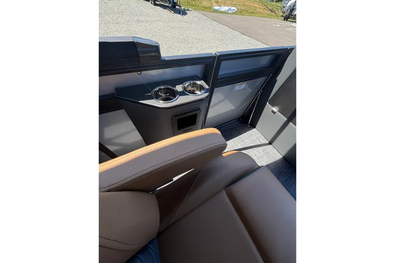 Slide: The Image of Interior of 2026 Whisper V23 RLS boat with cup holders and brown seating. - 13