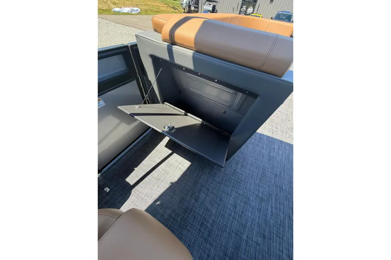 Slide: The Image of 2026 Whisper V23 RLS boat seat with integrated storage compartment, open on a sunny day. - 14