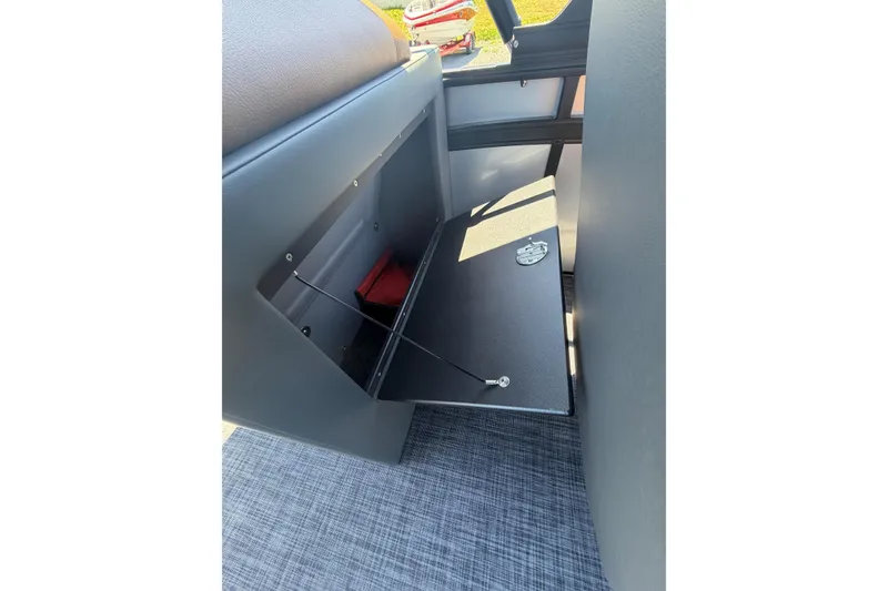 Slide: The Image of Open storage compartment in 2026 Whisper V23 RLS boat, featuring secure latch and interior space. - 23