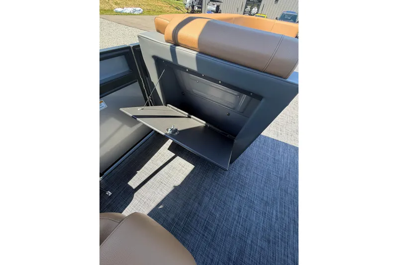 Slide: The Image of Open storage compartment in Whisper V23 RLS, 2026 model, with tan seating and gray flooring. - 25