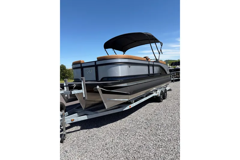 Slide: The Image of 2026 Whisper V23 RLS pontoon boat on trailer under clear blue sky. - 4