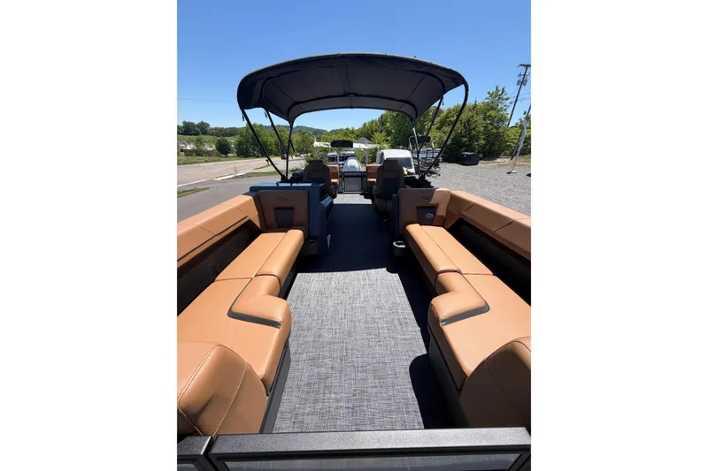 Slide: The Image of Interior view of 2026 Whisper V23 RLS pontoon boat with tan seating and canopy. - 9