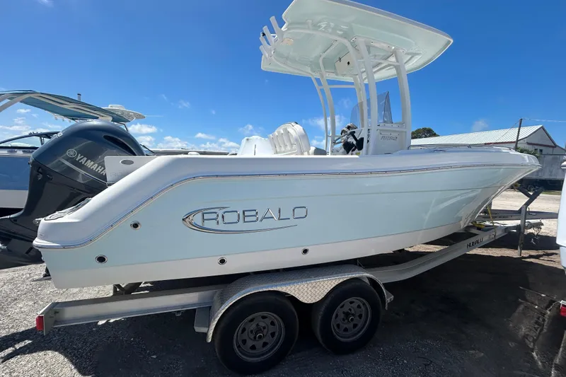 Slide: The Image of 2021 Robalo R222 Explorer boat on trailer, side view under clear blue sky. - 1
