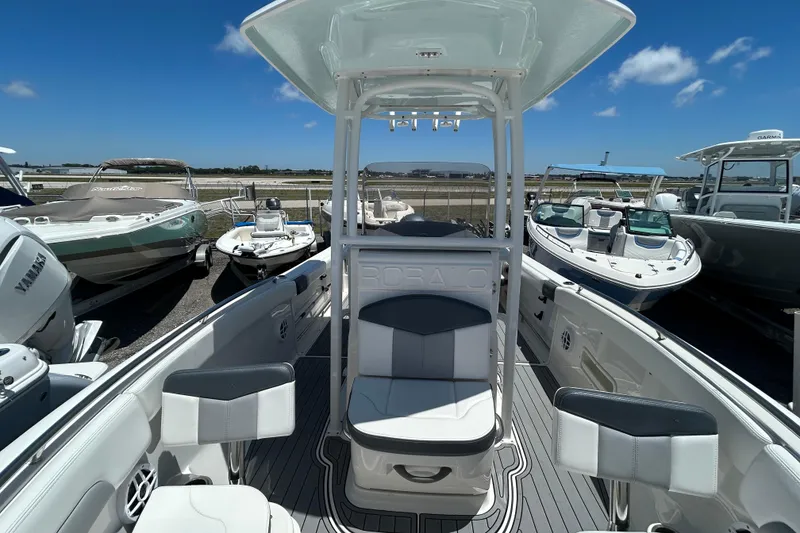 Slide: The Image of 2021 Robalo R222 Explorer boat interior with seating, docked under clear blue sky. - 13