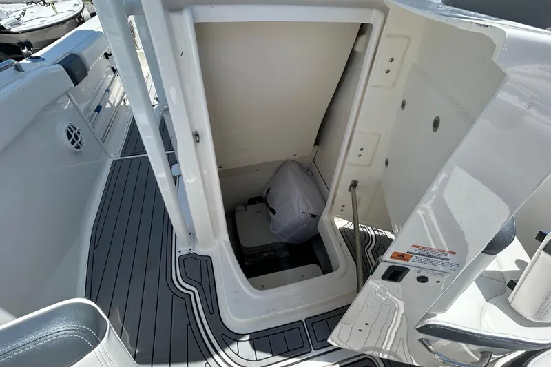 Slide: The Image of 2021 Robalo R222 Explorer boat storage compartment with open hatch and visible interior. - 14