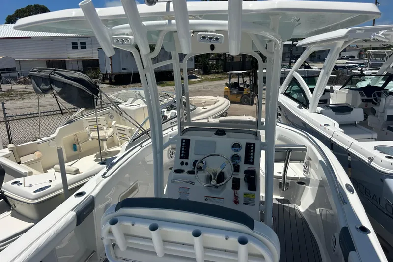 Slide: The Image of 2021 Robalo R222 Explorer boat interior with steering console and seating, docked among other boats. - 8