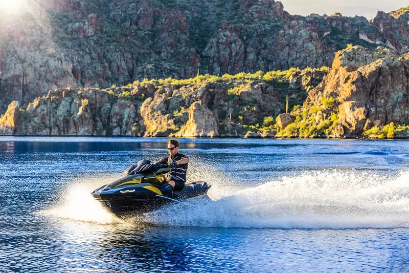 Slide: The Image of 2023 Kawasaki JET SKI ULTRA 160LX on a lake with rocky backdrop. - 20