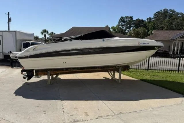 Slide: The Image of 2012 Stingray 235 LR boat on a trailer in a driveway setting. - 14