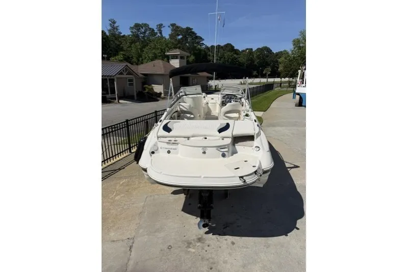 Slide: The Image of 2012 Stingray 235 LR boat on trailer, parked outdoors in a sunny setting. - 3