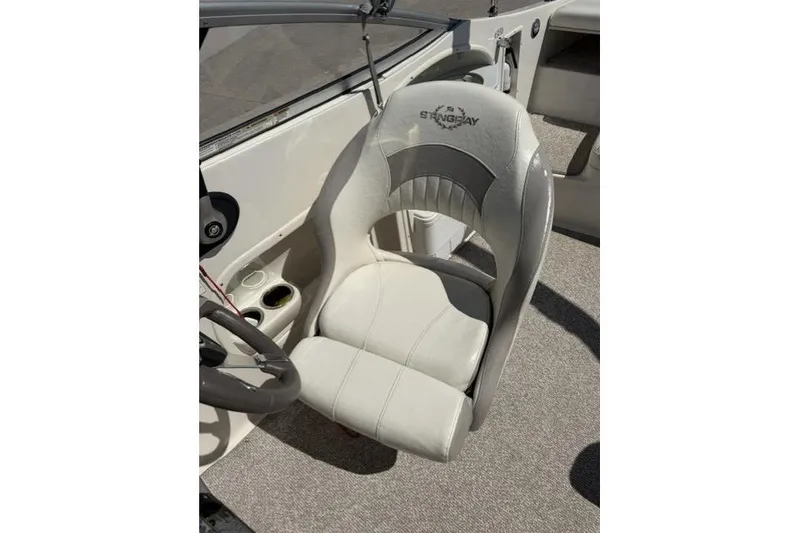 Slide: The Image of Captain's seat of a 2012 Stingray 235 LR boat, featuring white upholstery. - 6