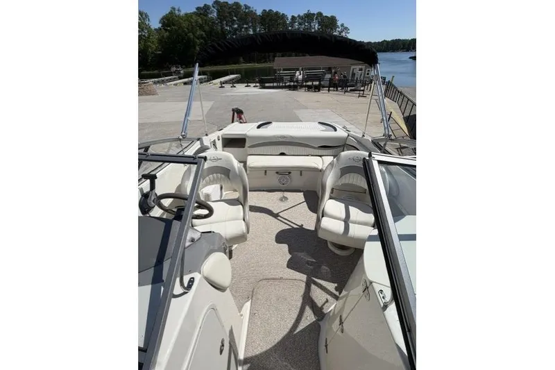 Slide: The Image of 2012 Stingray 235 LR boat interior with seating, docked by a lake. - 8
